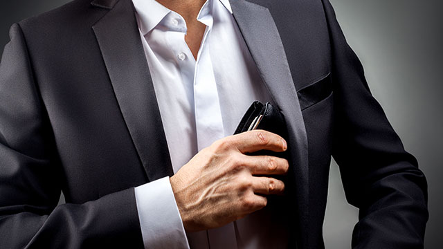 man in suit with putting wallet in jacket